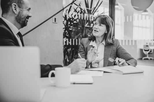 Professional woman looking concerned at her desk — concept of being managed out of her job in a corporate workplace